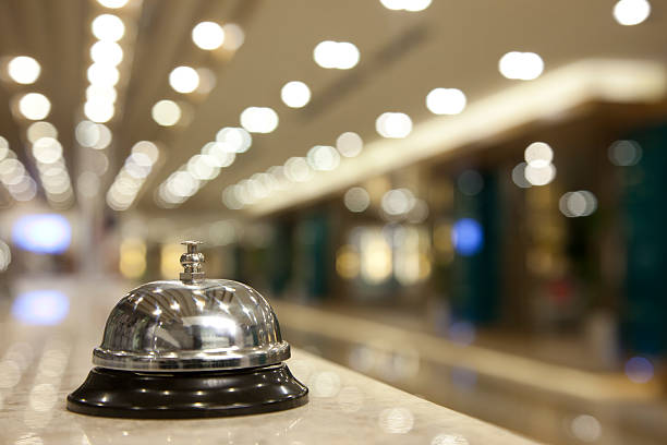 Elegant concierge service bell on a marble counter with soft bokeh lights in the background